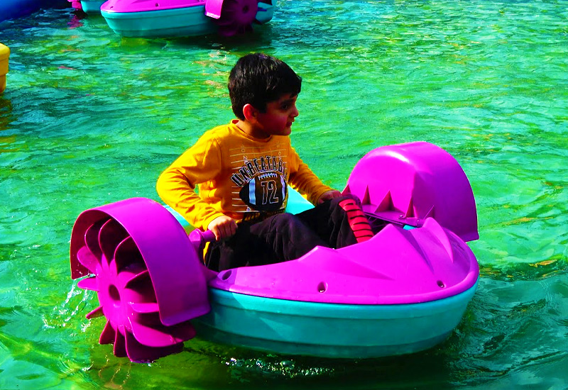 Kids paddle boat in shallow pool